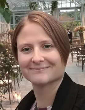 Close-up portraitphoto of Susanne Boethius. Susanne has short light hair and blue eyes, smiling, looking into the camera